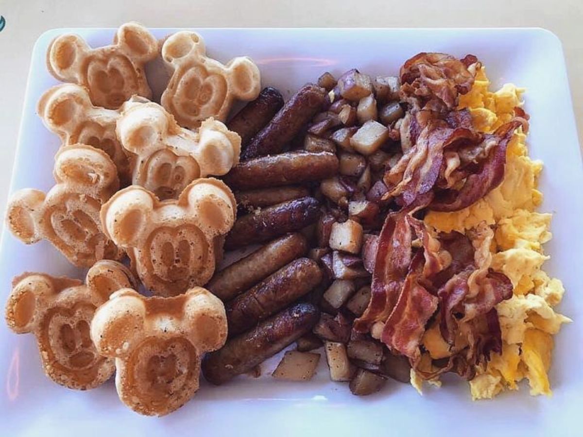 breakfast plate at The Plaza Inn In Disneyland that has mickey waffles, sausage, potatoes, bacon, and eggs.